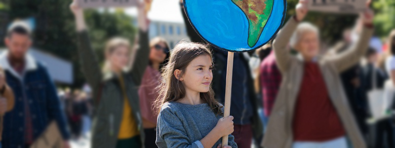 Young girl holding a globe placard