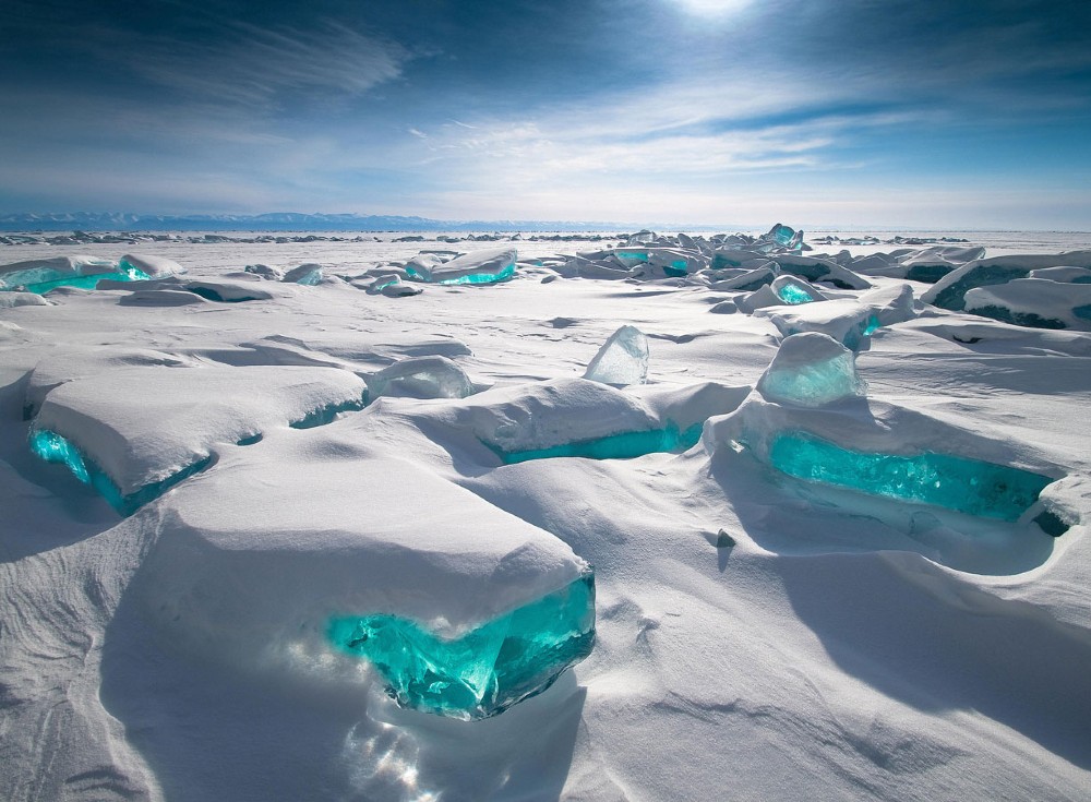 Blocks of ice with turquoise shining through under a blue sunny sky