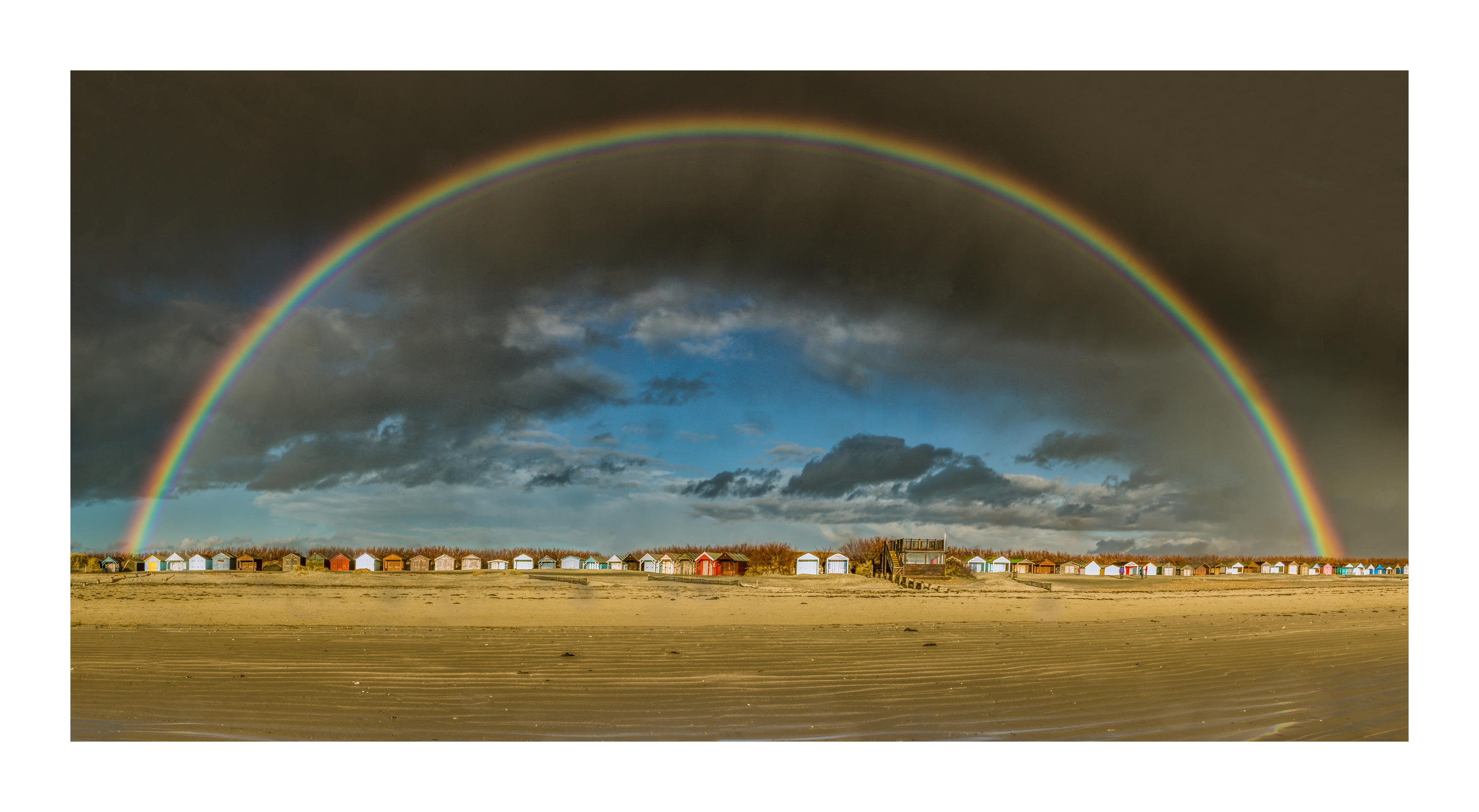 Rainbow over beach huts