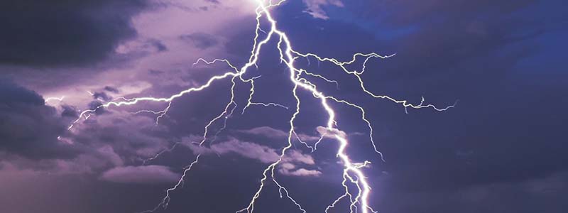 Lightning in front of a purple sky