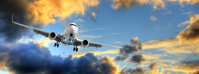 Image of an airplane flying in front of clouds