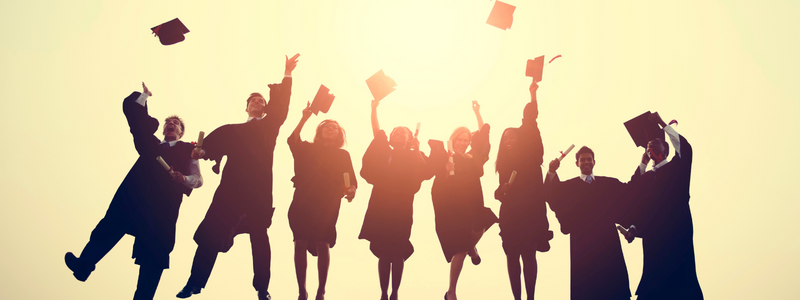 Image of students throwing their graduation caps in the air