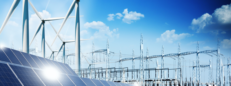 Image of wind turbines and solar panels (left foreground) with power lines in the background against blue sky with light cloud