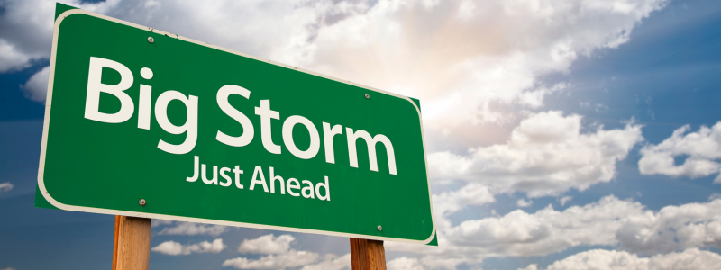 Image of a green sign with the wording "big storm just ahead" in front of a cloudy sky