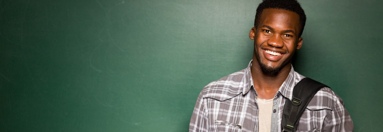 A student smiles against a green background