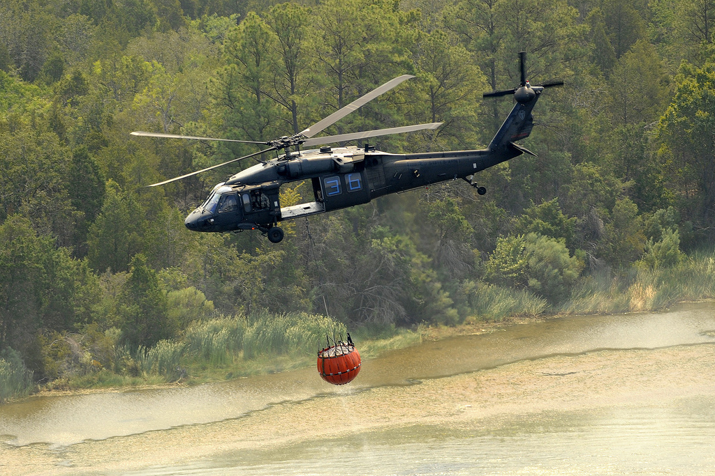  Three Texas National Guard helicopters dump their water-filled &#039;bambi buckets&#039; on a wildfire in September 2011