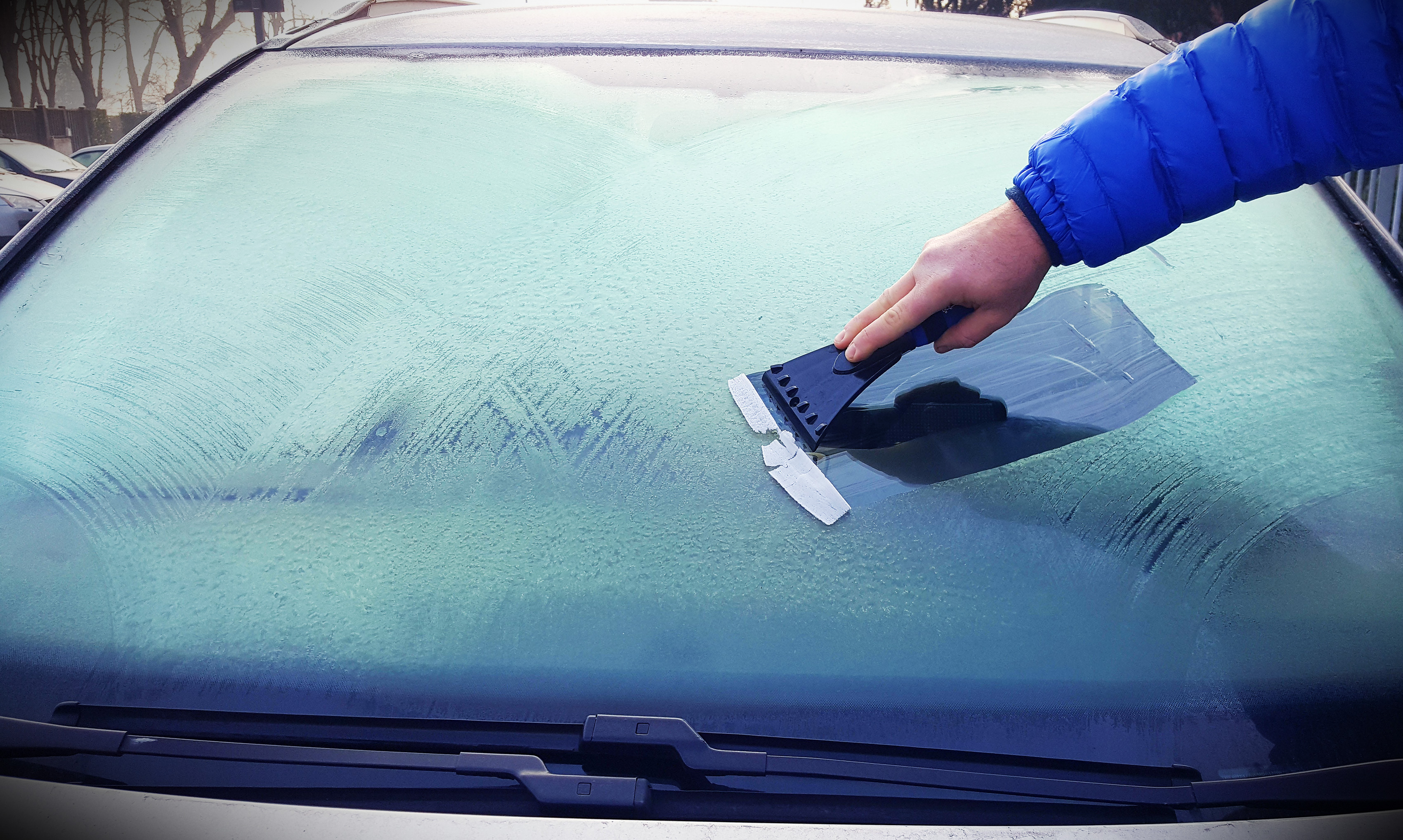 Scraping ice off car windscreen