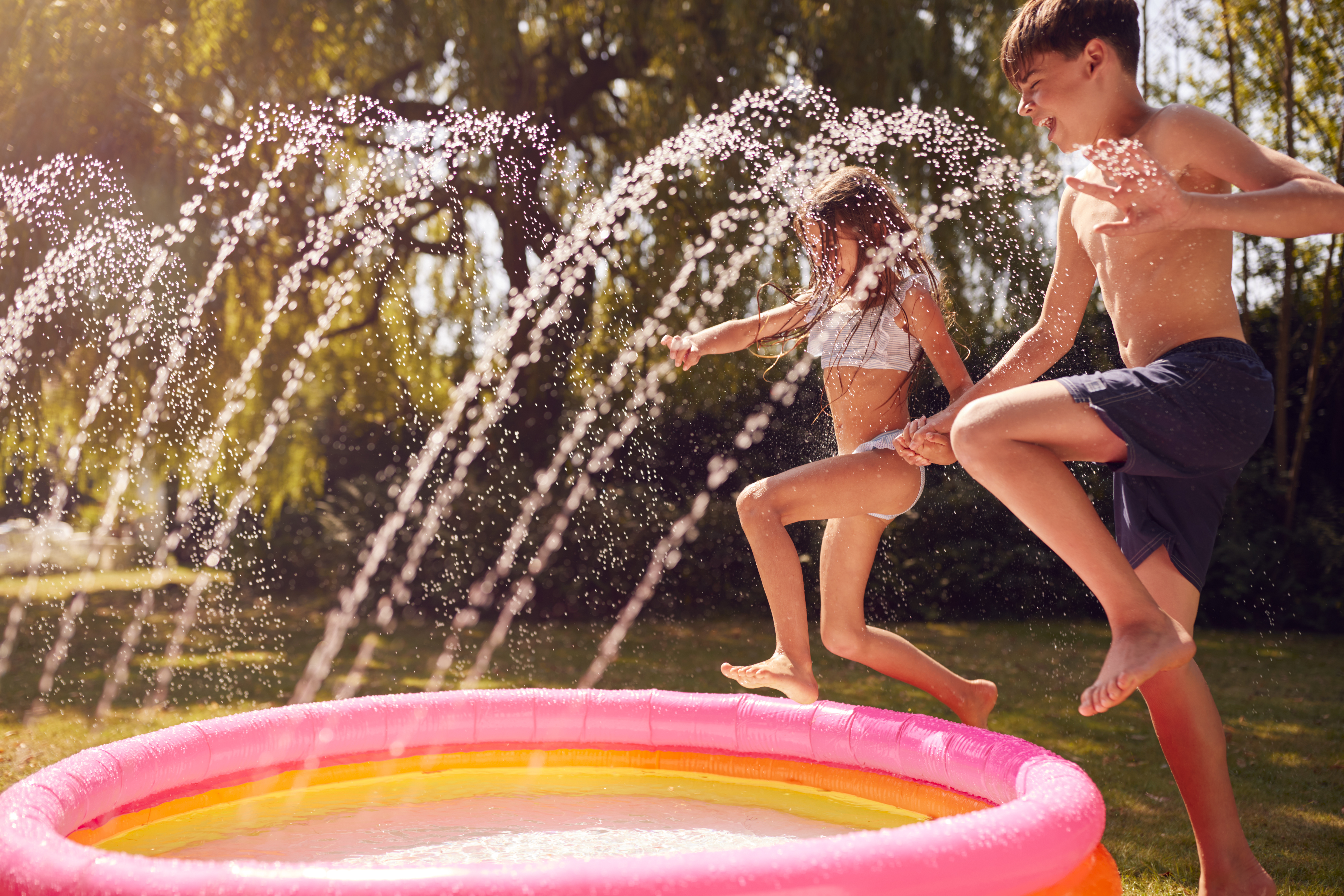 Children jumping into a paddling pool