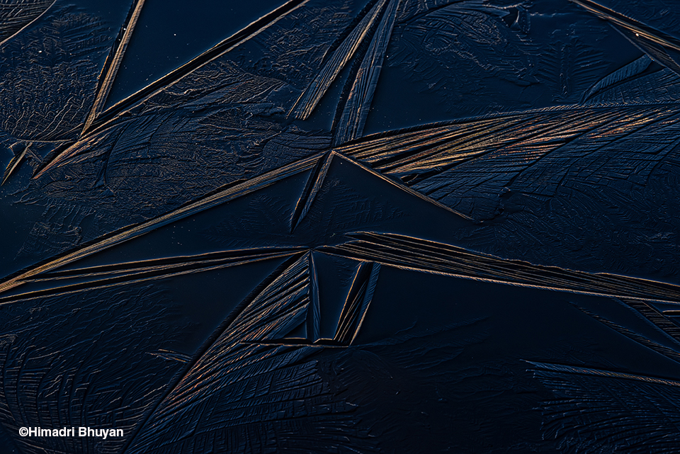 Fractal ice patterns stretch across Pangateng Tso Lake in India, frozen in delicate shapes. Climate change is disrupting traditional freeze-thaw cycles, affecting fragile mountain ecosystems.