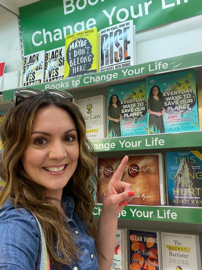 Laura pointing at her book