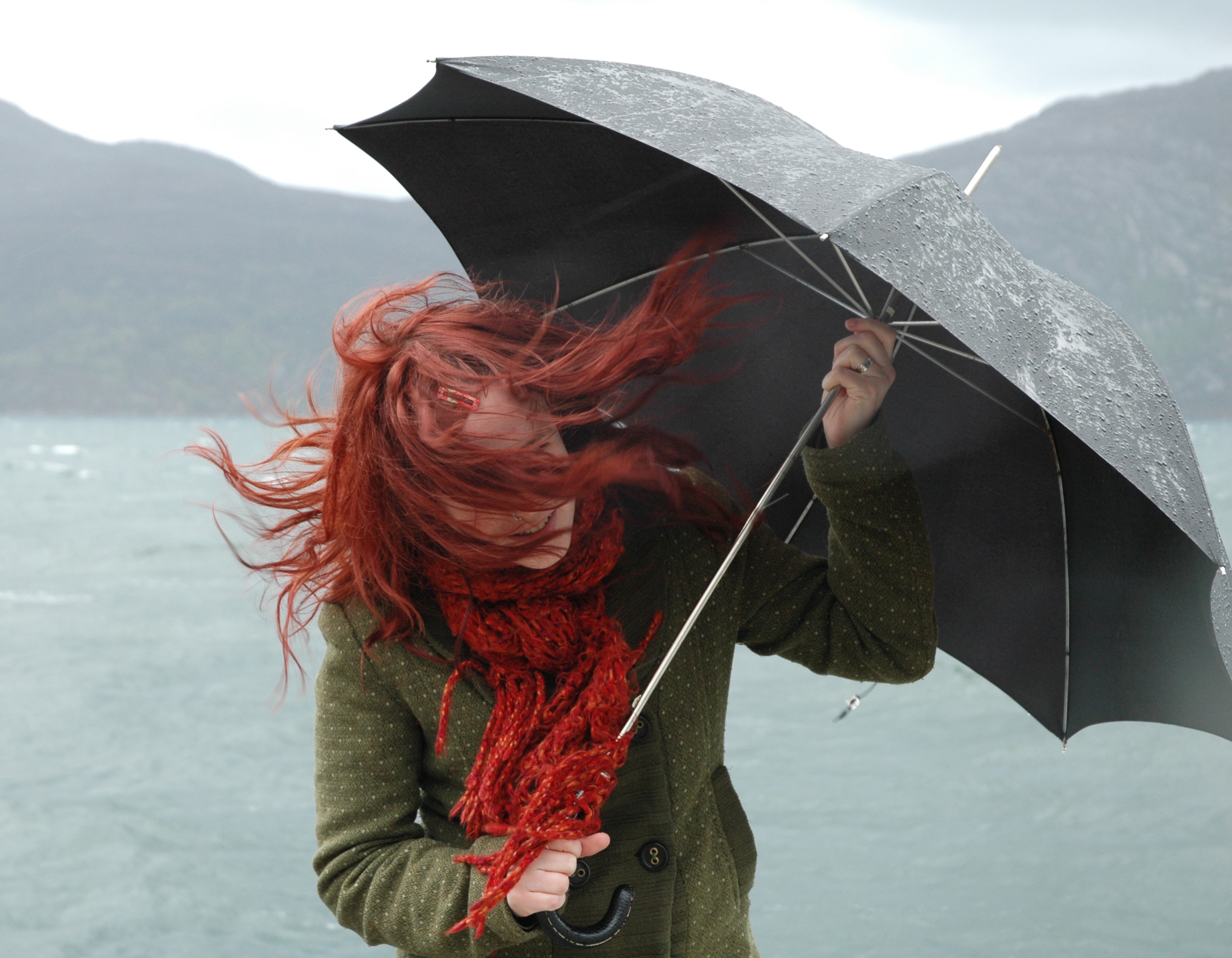 women battles with umbrella in strong winds