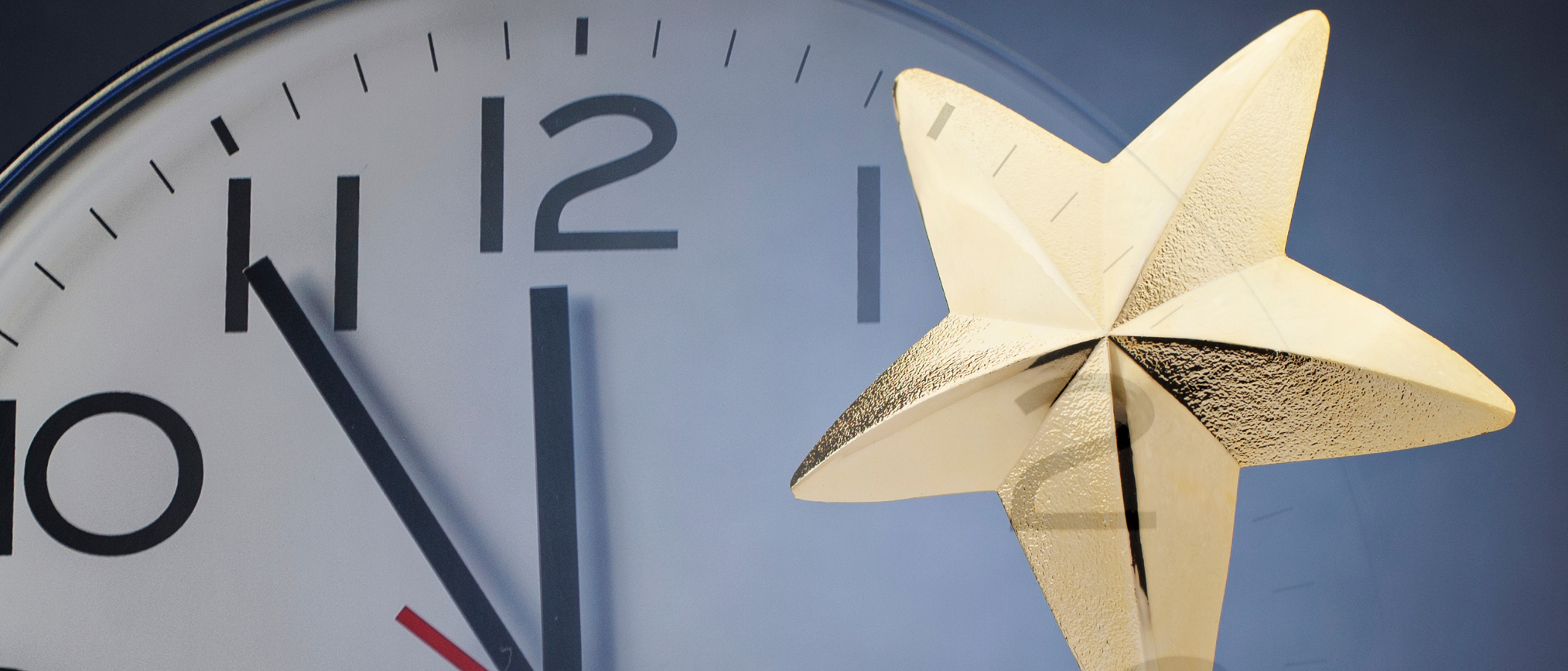 A star award trophy in front of a clock face