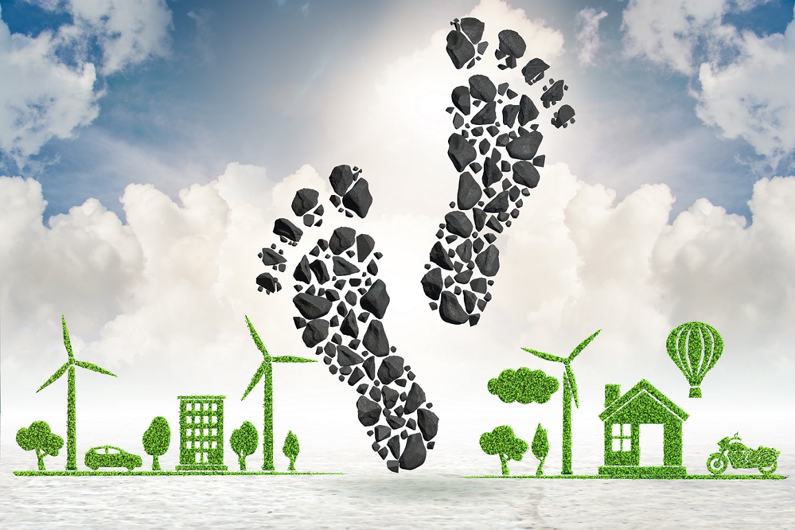 an illustration of a carbon footprint with buildings, trees, vehicles and wind turbines formed out of leaves