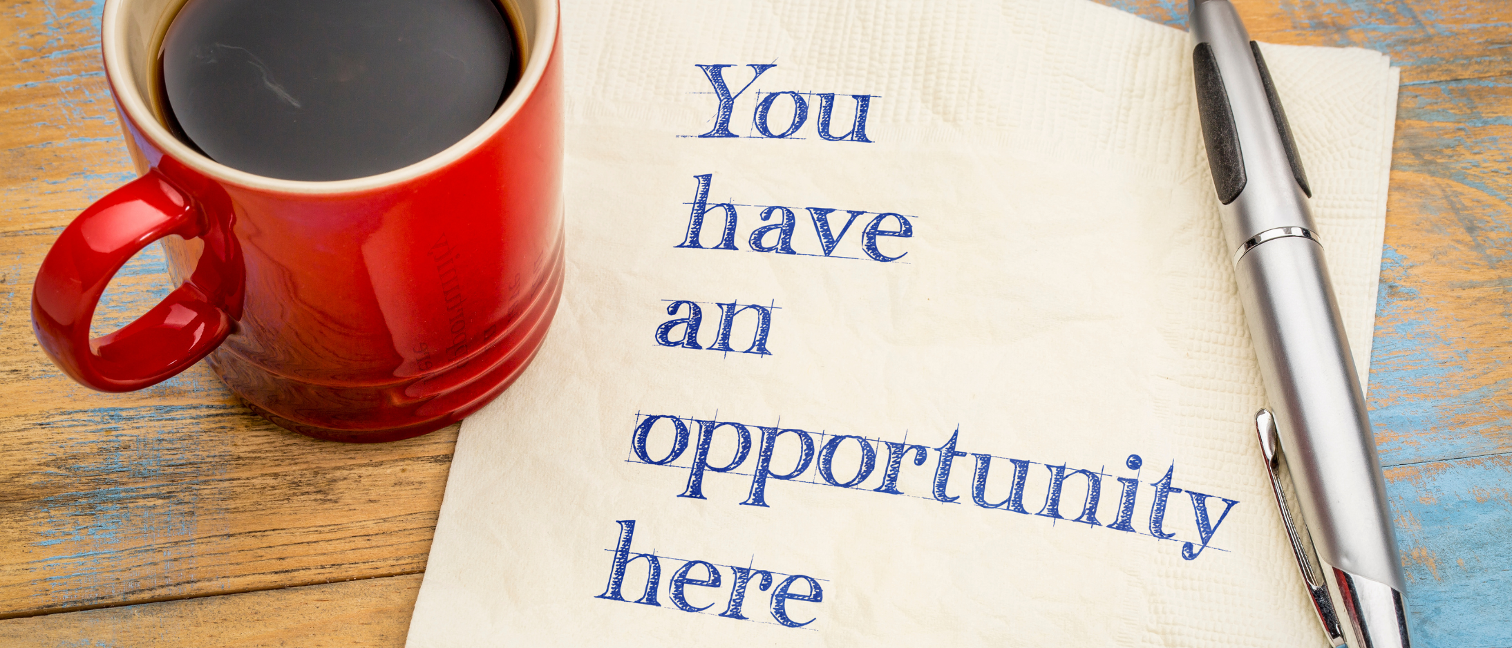 a mug of black coffee and a pen with a napkin saying 'You have an opportunity here'
