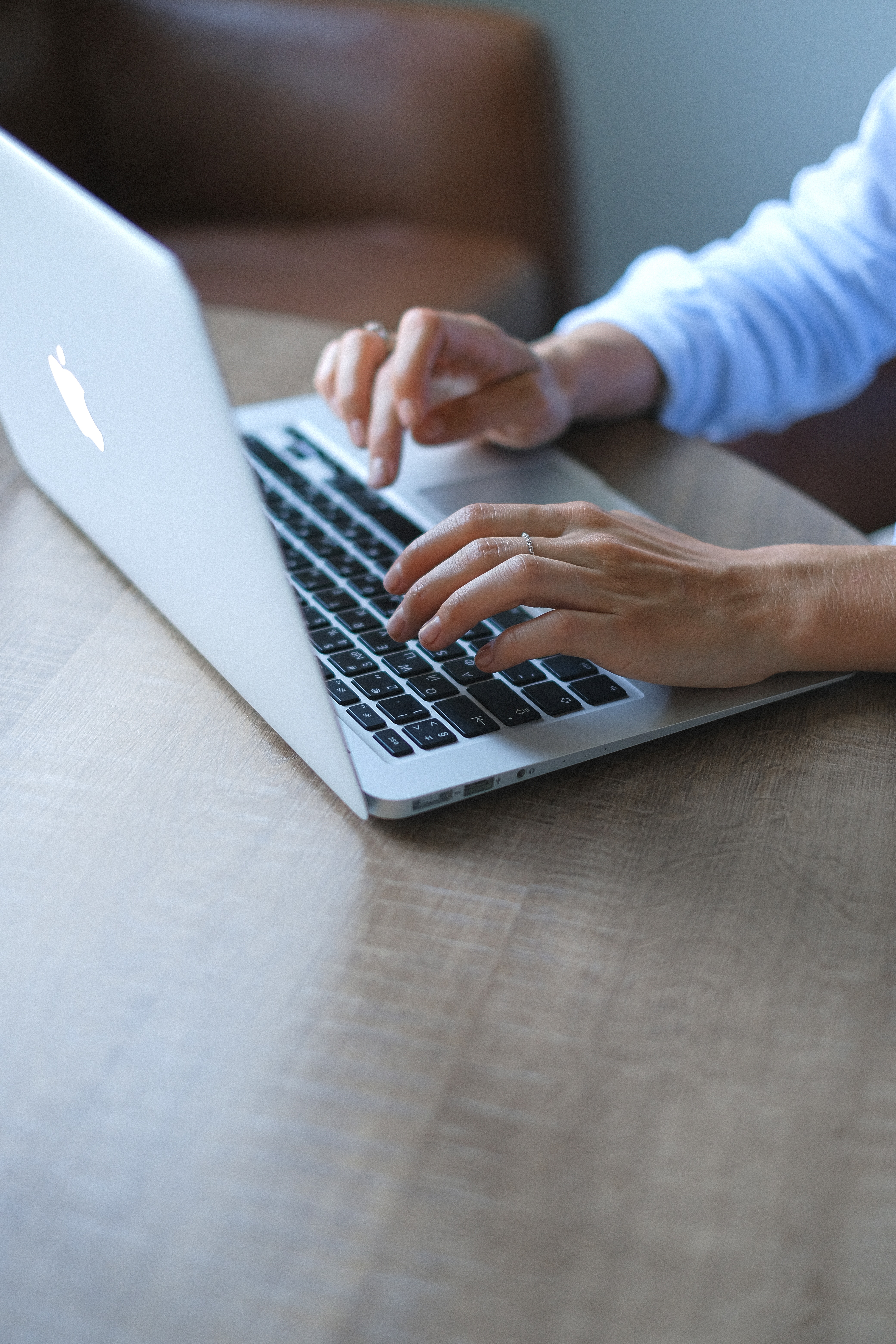 Hands typing on laptop