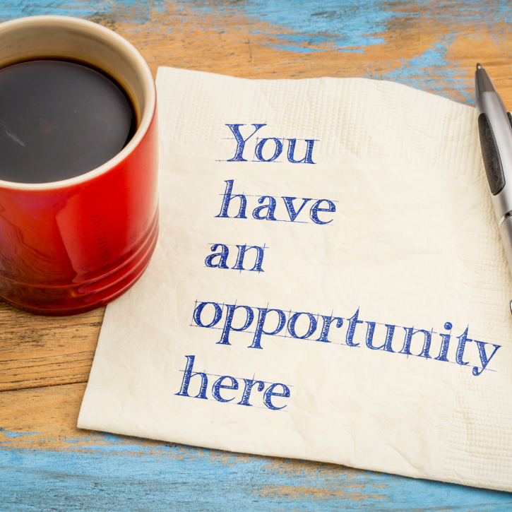 a mug of black coffee and a pen with a napkin saying 'You have an opportunity here'