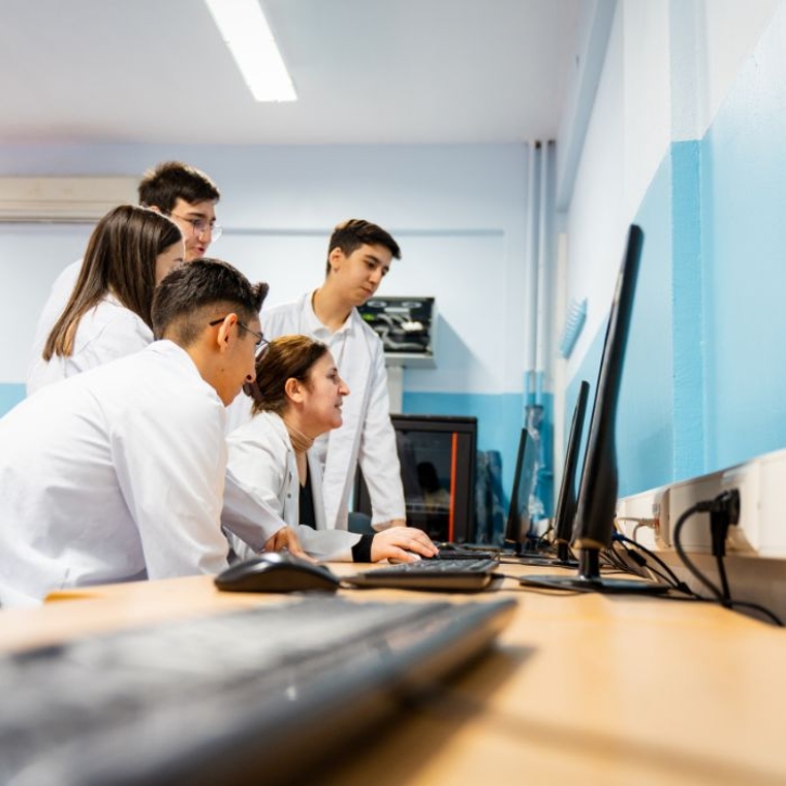 Students gather around a computer screen