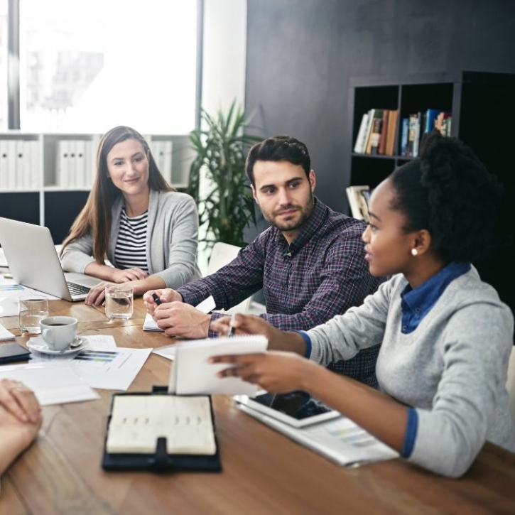 A group of people talk around a table