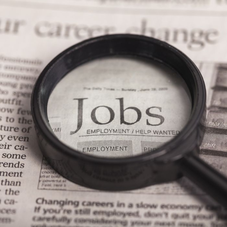 A magnifying glass rests on a newspaper