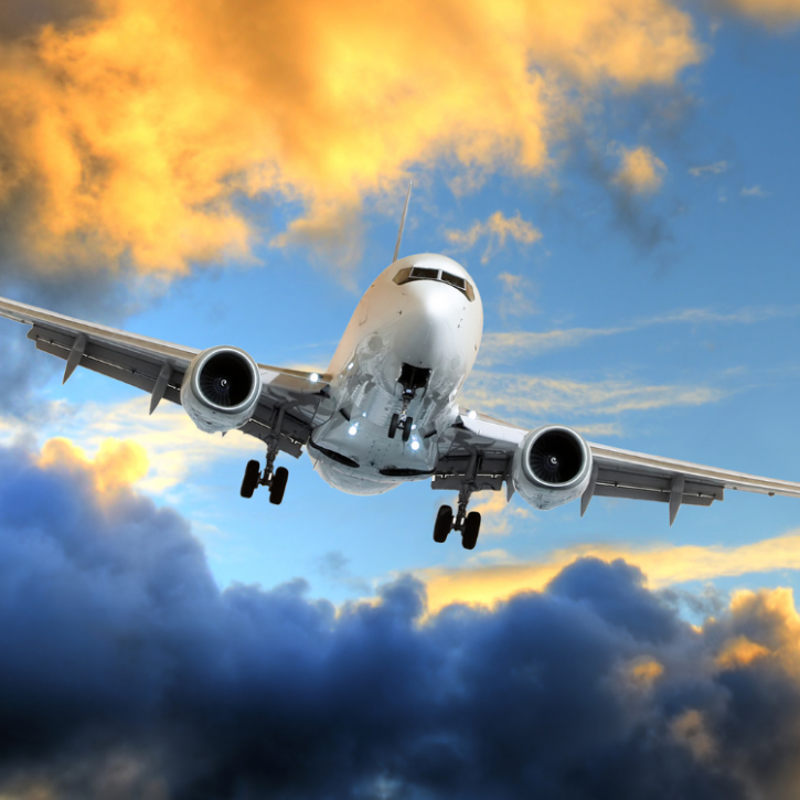 Image of an airplane flying in front of clouds