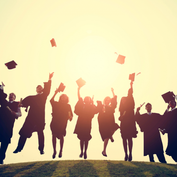 Image of students throwing graduation caps in the air