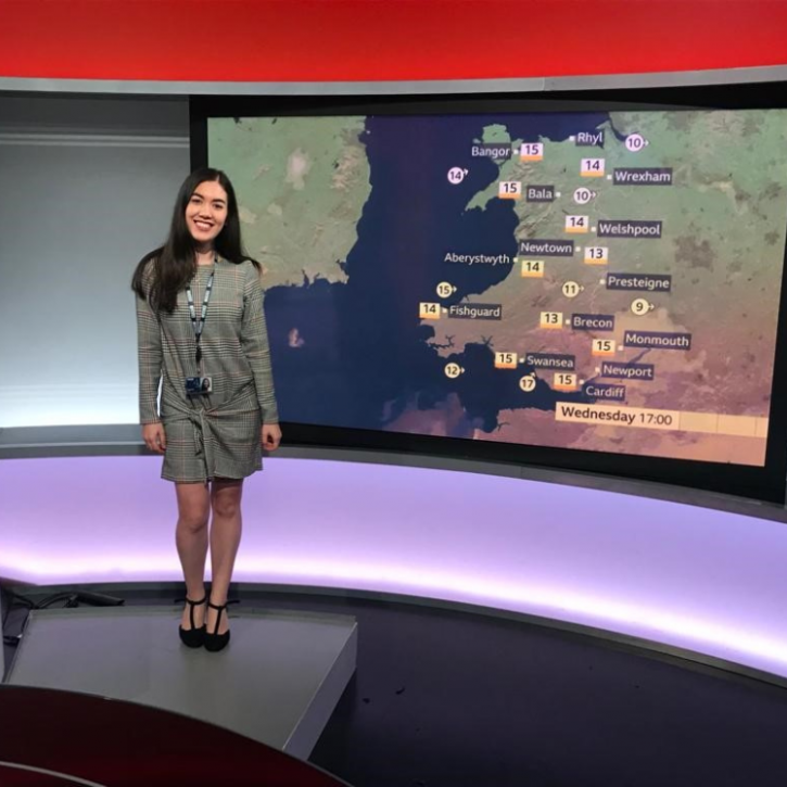Image of a weather woman standing in front of a map of Wales showing the weather