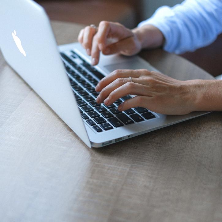 Hands typing on laptop